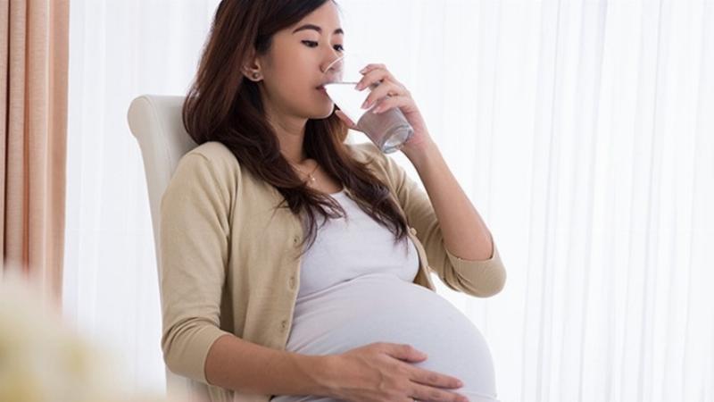 Hình ảnh mô tả ảnh hưởng của việc thiếu canxi đối với mẹ bầu và thai nhi, thể hiện các vấn đề như chuột rút, đau lưng ở mẹ và chậm phát triển xương ở bé